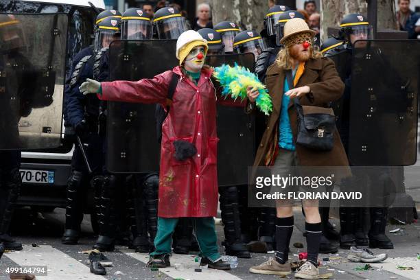 Protestors dressed as clowns stand in front of police as demonstrators clash with police during a rally against global warming on November 29, 2015...