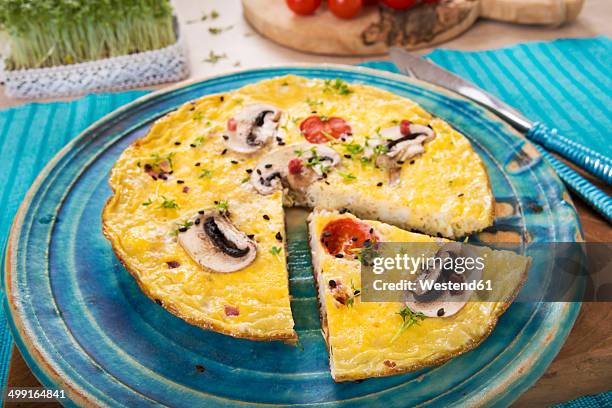 frittata with champignon, ham cubes, tomatos, sesame and cress on plate - frittata stock-fotos und bilder