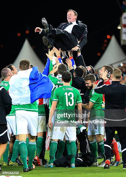 Northern Ireland players throw Northern Ireland manager Michael O'Neill up in the air as they celebrate victory and qualification after the UEFA EURO...