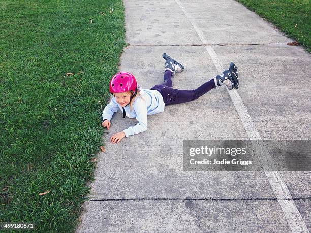 child on ground after falling over inline skates - inline skating - fotografias e filmes do acervo