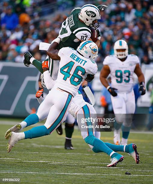 Eric Decker of the New York Jets makes a catch against Reshad Jones, and Neville Hewitt of the Miami Dolphins in the second quarter during their game...