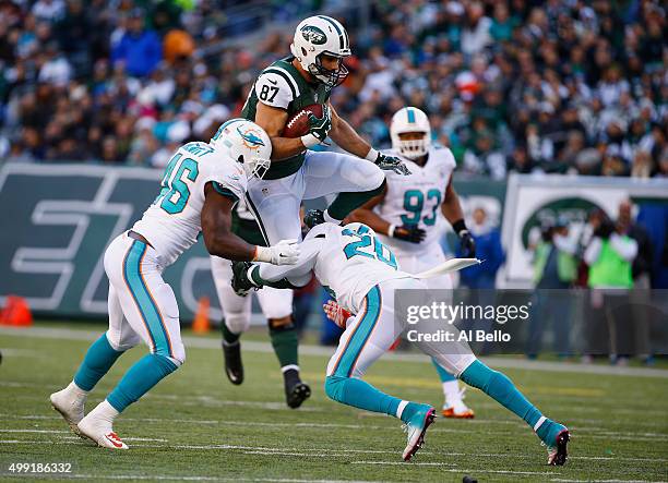 Eric Decker of the New York Jets makes a catch against Reshad Jones, and Neville Hewitt of the Miami Dolphins in the second quarter during their game...