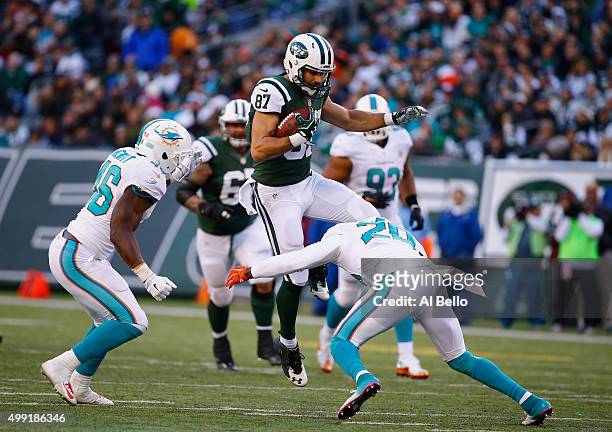 Eric Decker of the New York Jets makes a catch against Reshad Jones, and Neville Hewitt of the Miami Dolphins in the second quarter during their game...