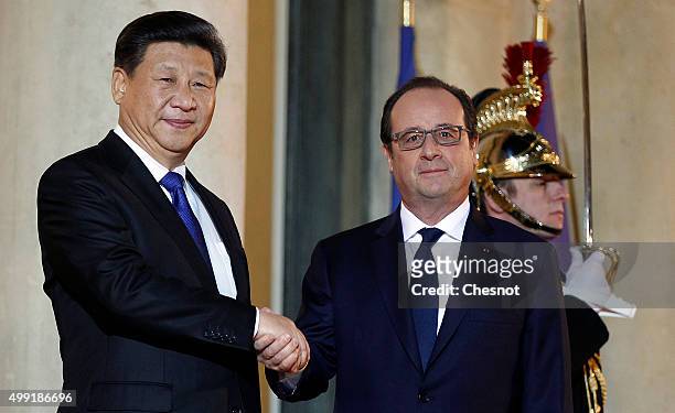 French President Francois Hollande welcomes Chinese President Xi Jinping prior to attend a working dinner at the Elysee Presidential Palace on...