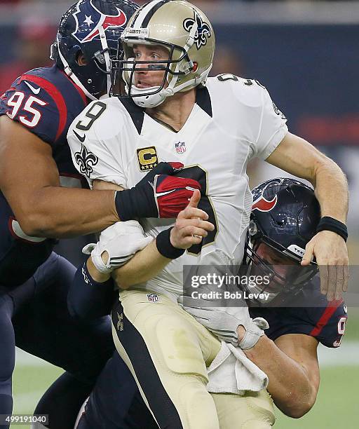 Drew Brees of the New Orleans Saints is hit by Christian Covington of the Houston Texans and J.J. Watt of the Houston Texans in the fourth quarter on...