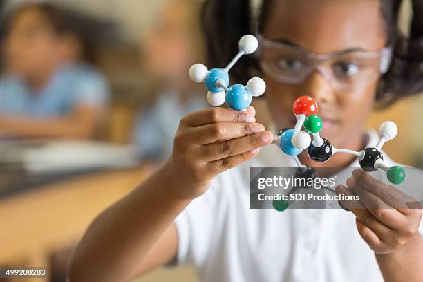 elementary science student using plastic atom model educational toy - stem stock pictures, royalty-free photos & images