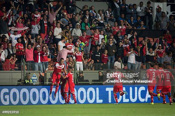 Fernando Uribe celebrates with his teammates after scoring the opening goal during the quarterfinals second leg match between Toluca and Puebla as...