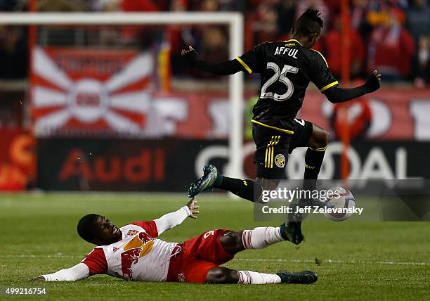 Harrison Afful of Columbus Crew jumps over Kemar Lawrence of New York Red Bulls during their match at Red Bull Arena on November 29, 2015 in...