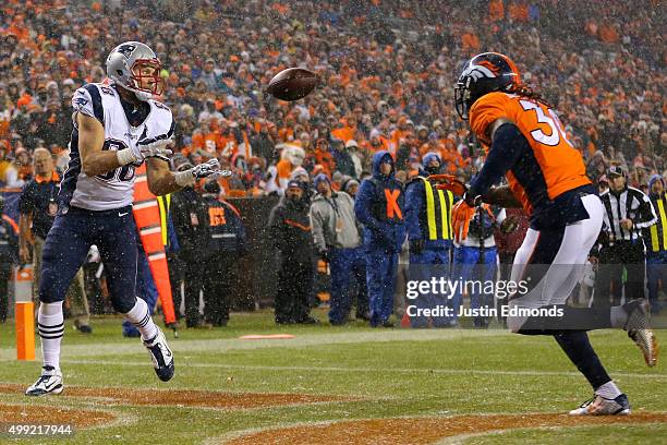 Tight end Scott Chandler of the New England Patriots scores a second quarter touchdown past strong safety David Bruton of the Denver Broncos at...