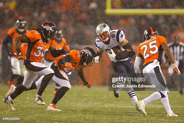 Tight end Rob Gronkowski of the New England Patriots carries the ball against free safety Darian Stewart of the Denver Broncos, strong safety David...