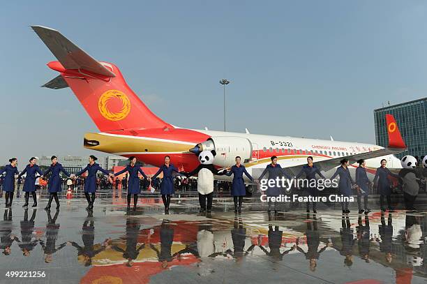 Staff celebrate the arrival of the ARJ21 jet at the airport on November 29, 2015 in Chengdu, China. It is the first ARJ, a regional jet made by...