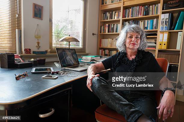 woman posing by her desk at home office - zelfvertrouwen stockfoto's en -beelden