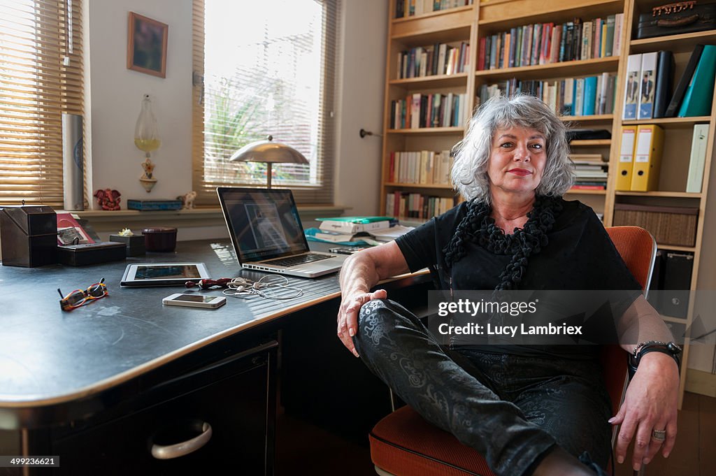 Woman posing by her desk at home office