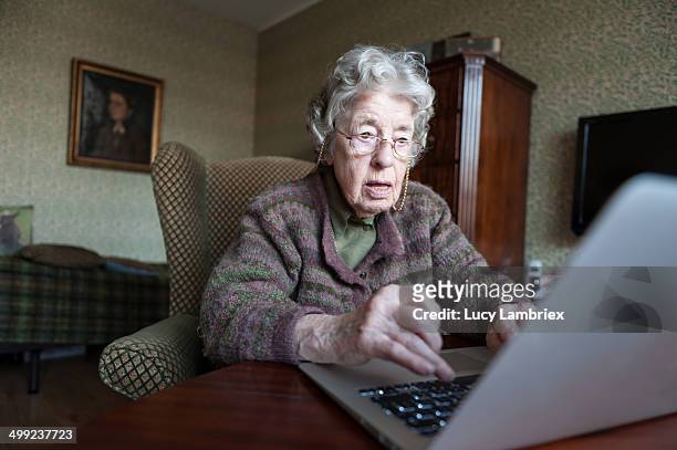 97-year-old lady with a laptop - sólo mujeres mayores fotografías e imágenes de stock