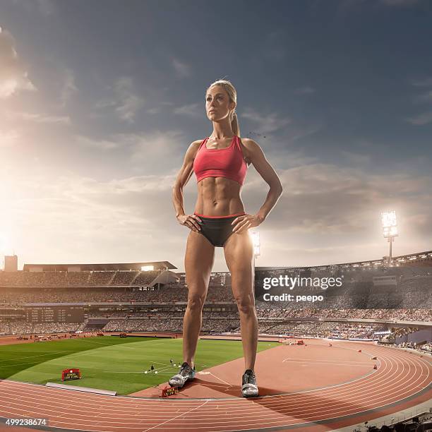 donna in piedi di atleta iant illuminati stadio di atletica leggera - largo foto e immagini stock