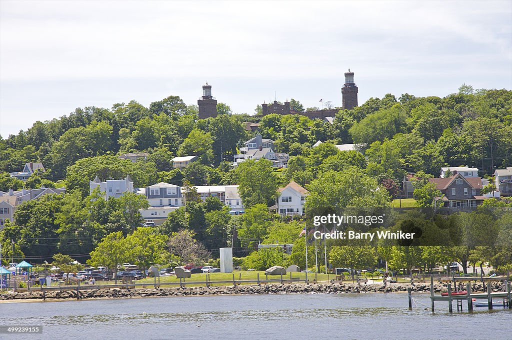 Two light towers atop hill with houses
