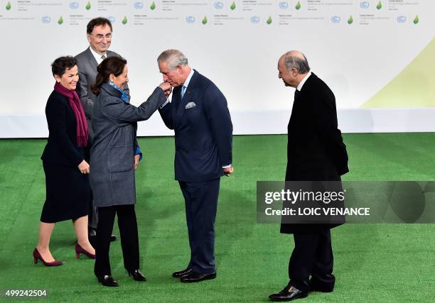 Britain's Prince Charles gives a kiss on the hand of French Minister of Ecology, Sustainable Development and Energy Segolene Royal , upon his arrival...