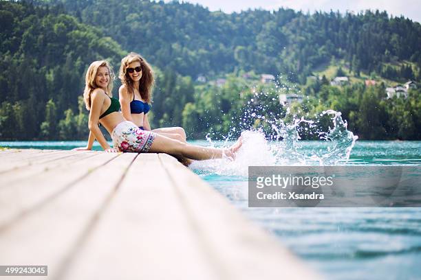 young women sitting on the pier - lake bled stockfoto's en -beelden