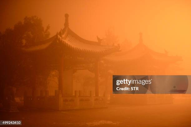 This picture taken on November 29, 2015 shows pagodas on a polluted day in Hohhot, north China's Inner Mongolia region. Northern China choked under...