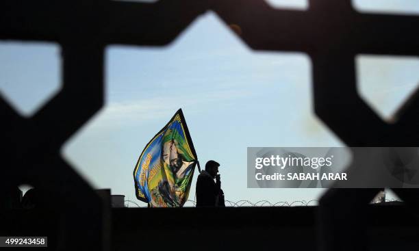 Shiite Muslim pilgrim walks on a main road in Baghdad's Dora district on November 30 as tens of thousands of observant Shiites head on foot towards...