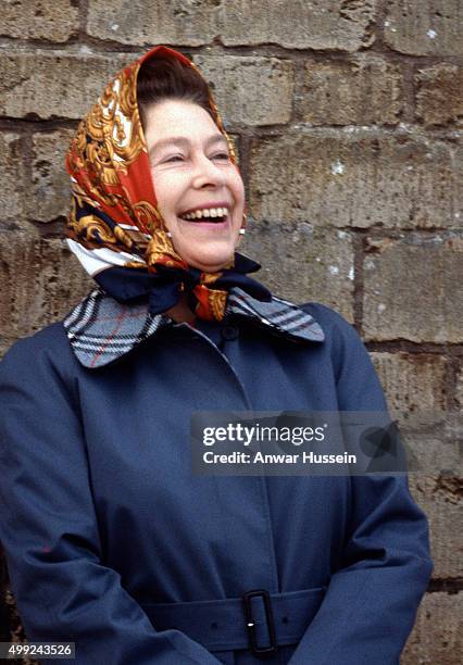 Queen Elizabeth ll, wearing a headscarf laughs during Badminton Horse Trials on April 01, 1979 in Badminton, England.