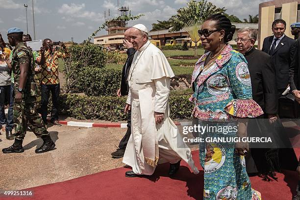 Pope Francis , flanked by Central African Republic interim president Catherine Samba-Panza walks to board a plane to leave at the Mpoko International...