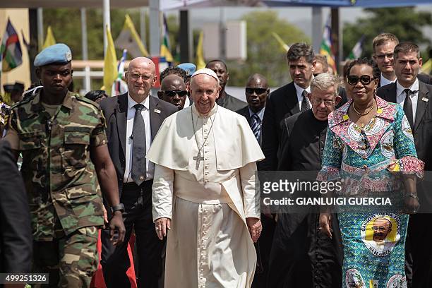 Pope Francis , flanked by Central African Republic interim president Catherine Samba-Panza walks to board a plane to leave at the Mpoko International...