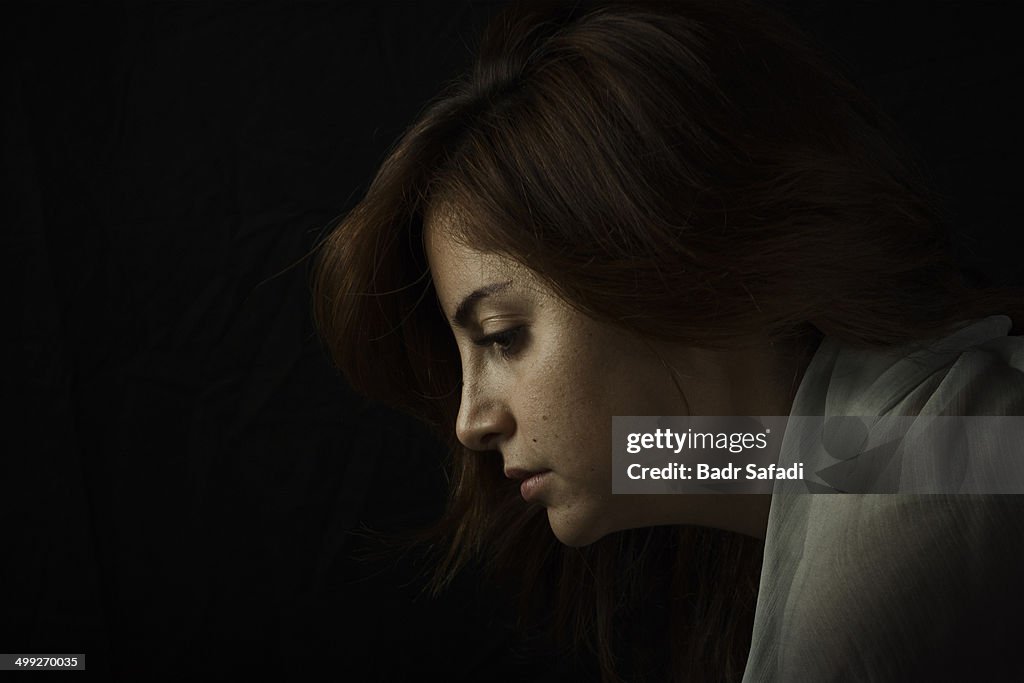 Profile of a pensive woman in low soft light