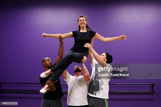 Cast members Travis Knights Ryan Foley and Danny Nielsen lift Allison Toffan while rehearsing for the Big Band Tap Revue in Toronto, Ontario.