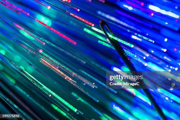 fiber optic passing through eye of needle - cámara lenta fotografías e imágenes de stock