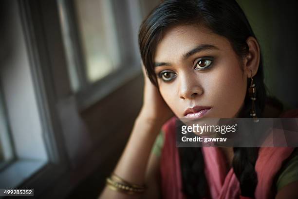 intérieur gros plan d'adolescente paisible asiatique fille assise près de la fenêtre. - low key photos et images de collection