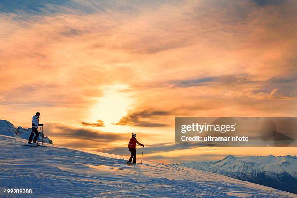 snow skiers couple  enjoying a beautiful winter mountains  sunset landscape - male female pair stockfoto's en -beelden