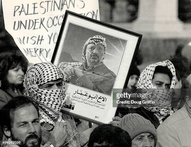 Showing support: Palestinian supporters; wearing traditional headdress; rally around a picture of Palestine Liberation Organization leader Yasser...