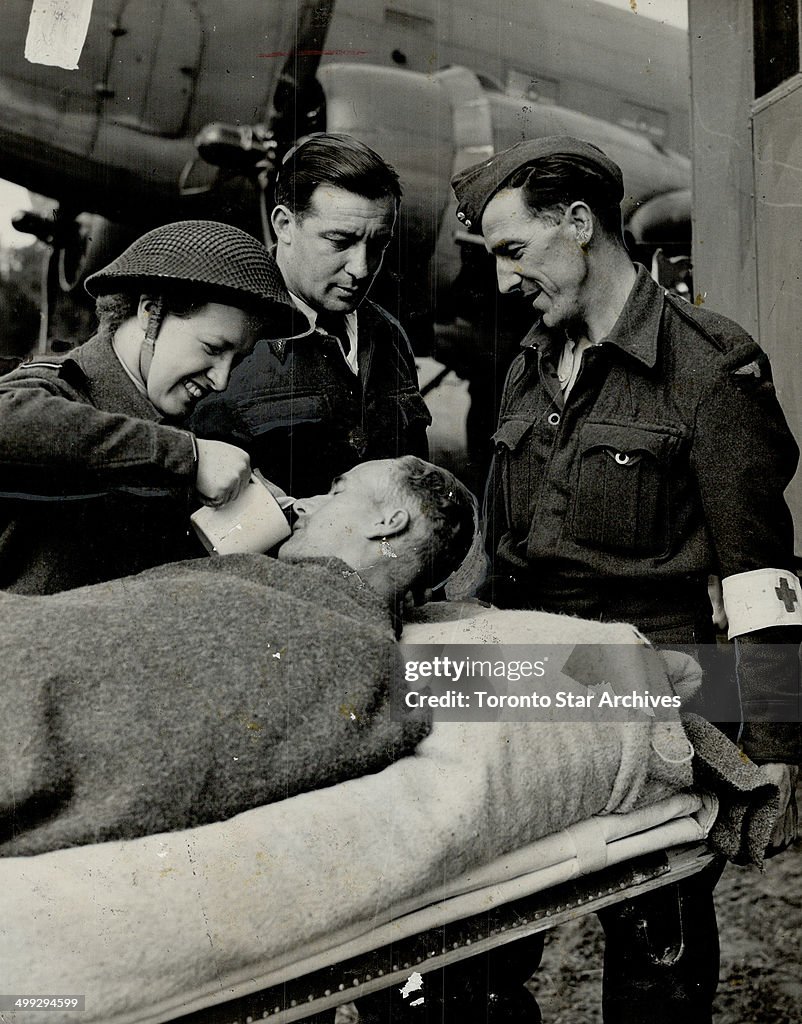 Air evacuation of Normandy casualties to England is fast and comfortable. Here a soldier is attended...
