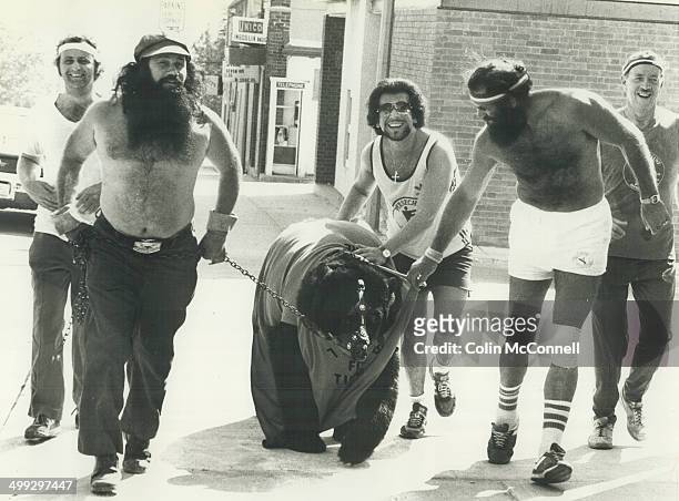 Smokey the bear jogs for charity. Smokey the Wrestling Bear is led over finish line by owner and trainer; Wild Man Dave McKigney; Bob Moffatt ; Joe...