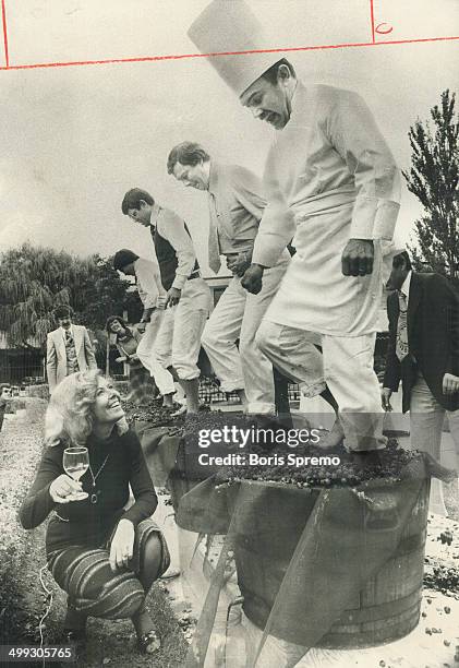 Toasting the new harvest; Encouraged by Pauline Waite; chef Claude Gambin gets both feel into act at grape stomping contest during Vendage'76 at Inn...