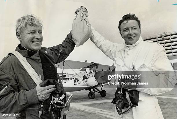 Holding aloft mail they flew to Malton from Montreal in Tiger Moth biplane in background are Thomas R. Lee and Donald L. Chamberlin. The flight...