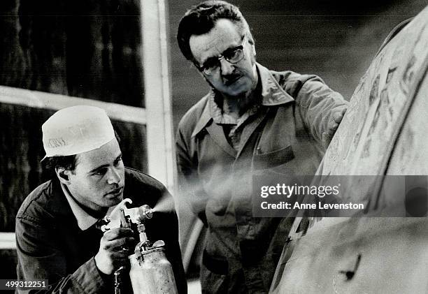 Job training: Harry Spencer; right; manager of the Salvation Army Community Autobody Shop; watches Ken Hansen; 25; spray paint a car. The shop trains...