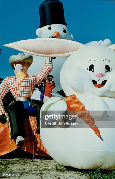 Giant inflatables inhabit backyard. Elizabeth Taylor and Hakan Colting wave from a perch in their Newmarket backyard. The snowman; cowboy and bunny...