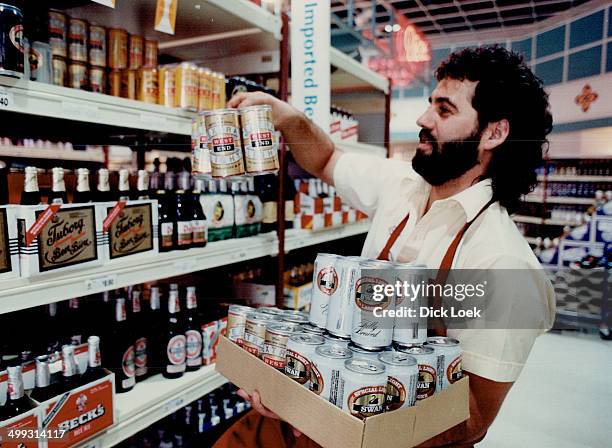 Stocking up: Luis Leandres stocks shelves of Crossroads liquor store with low-alcohol beers. Dr. Richard Richards; left; switched brands.