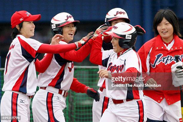 Megu Hirose of Japan is congratulated by her team mates after hitting a two-run homer in the top of first inning during the Japan Cup International...