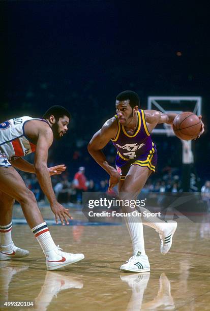 Adrian Dantley of the Utah Jazz dribbles past Greg Ballard of the Washington Bullets during an NBA basketball game circa 1980 at the Capital Centre...