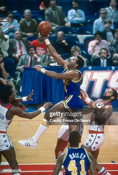 Adrian Dantley of the Utah Jazz shoots over Greg Ballard of the Washington Bullets during an NBA basketball game circa 1984 at the Capital Centre in...