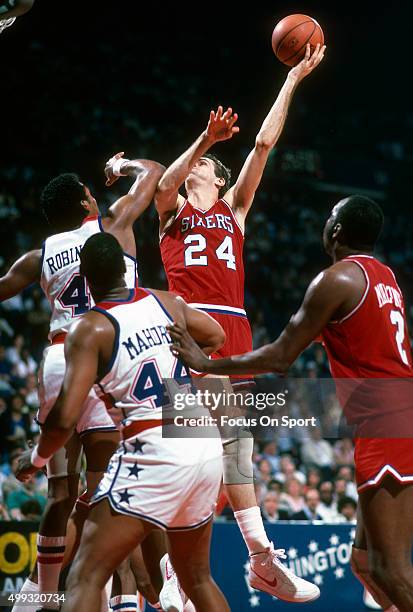 Bobby Jones of the Philadelphia 76ers shoots over Cliff Robinson of the Washington Bullets during an NBA basketball game circa 1984 at the Capital...