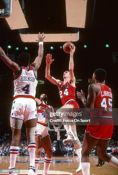 Bobby Jones of the Philadelphia 76ers shoots over Cliff Robinson of the Washington Bullets during an NBA basketball game circa 1984 at the Capital...