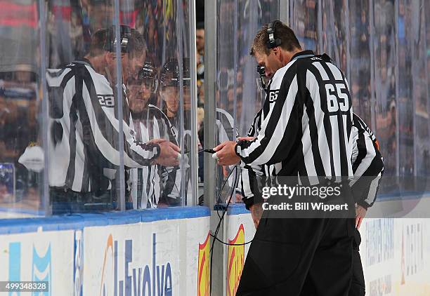 Linesman Pierre Racicot watches a replay for a video review during an NHL game between the St. Louis Blues and Buffalo Sabres on November 23, 2015 at...