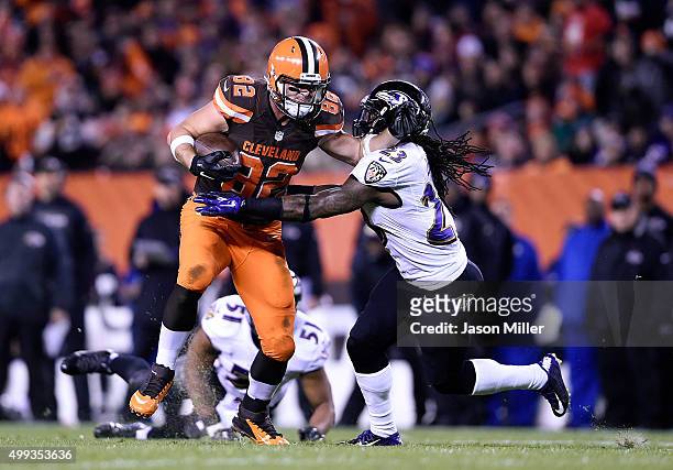 Gary Barnidge of the Cleveland Browns carries the ball in front of Kendrick Lewis of the Baltimore Ravens during the second quarter at FirstEnergy...