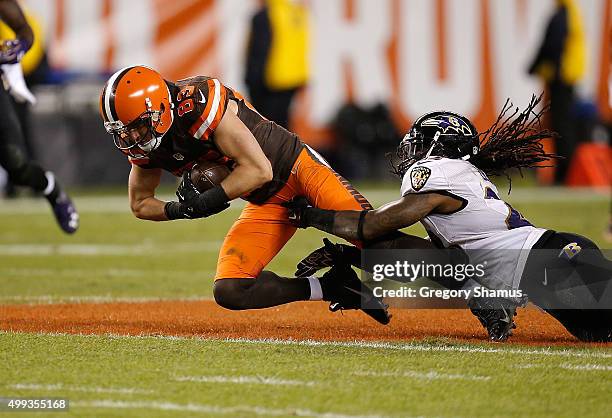 Brian Hartline of the Cleveland Browns gets tackled by Kendrick Lewis of the Baltimore Ravens during the second quarter at FirstEnergy Stadium on...