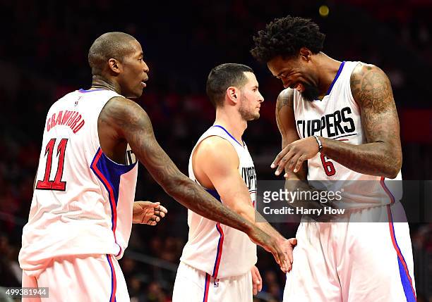 DeAndre Jordan of the Los Angeles Clippers reacts after making a free throw as Jamal Crawford and J.J. Redick give him a pat during a 102-87 Clipper...