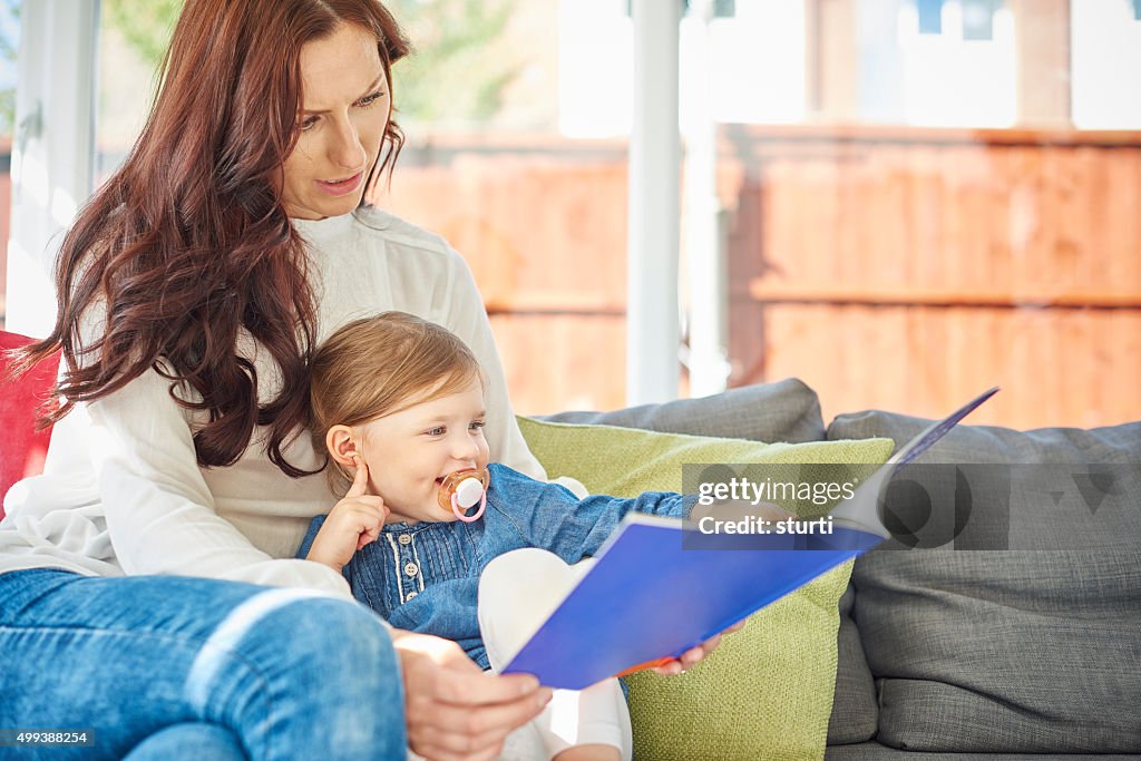 Mother and daughter reading a book together